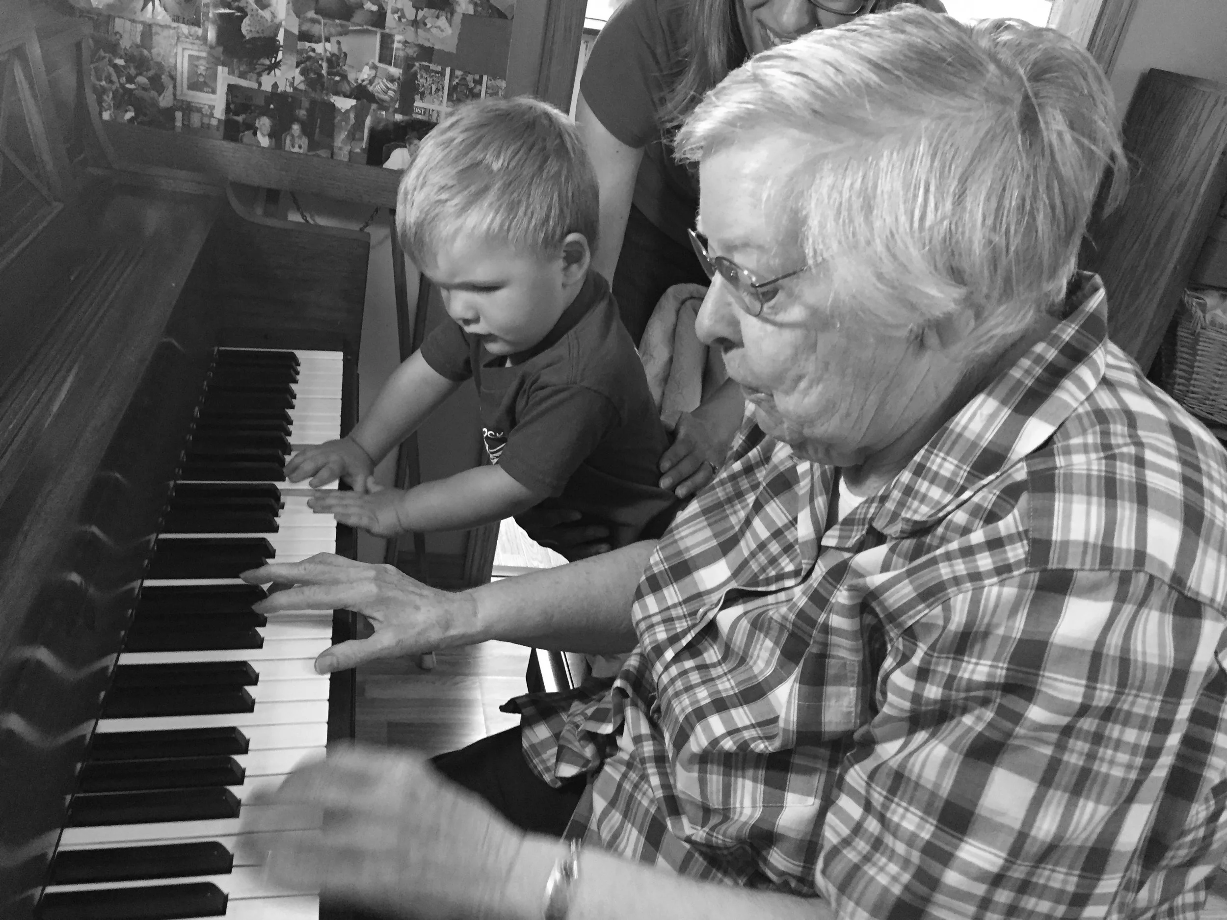 Resident and child playing piano together