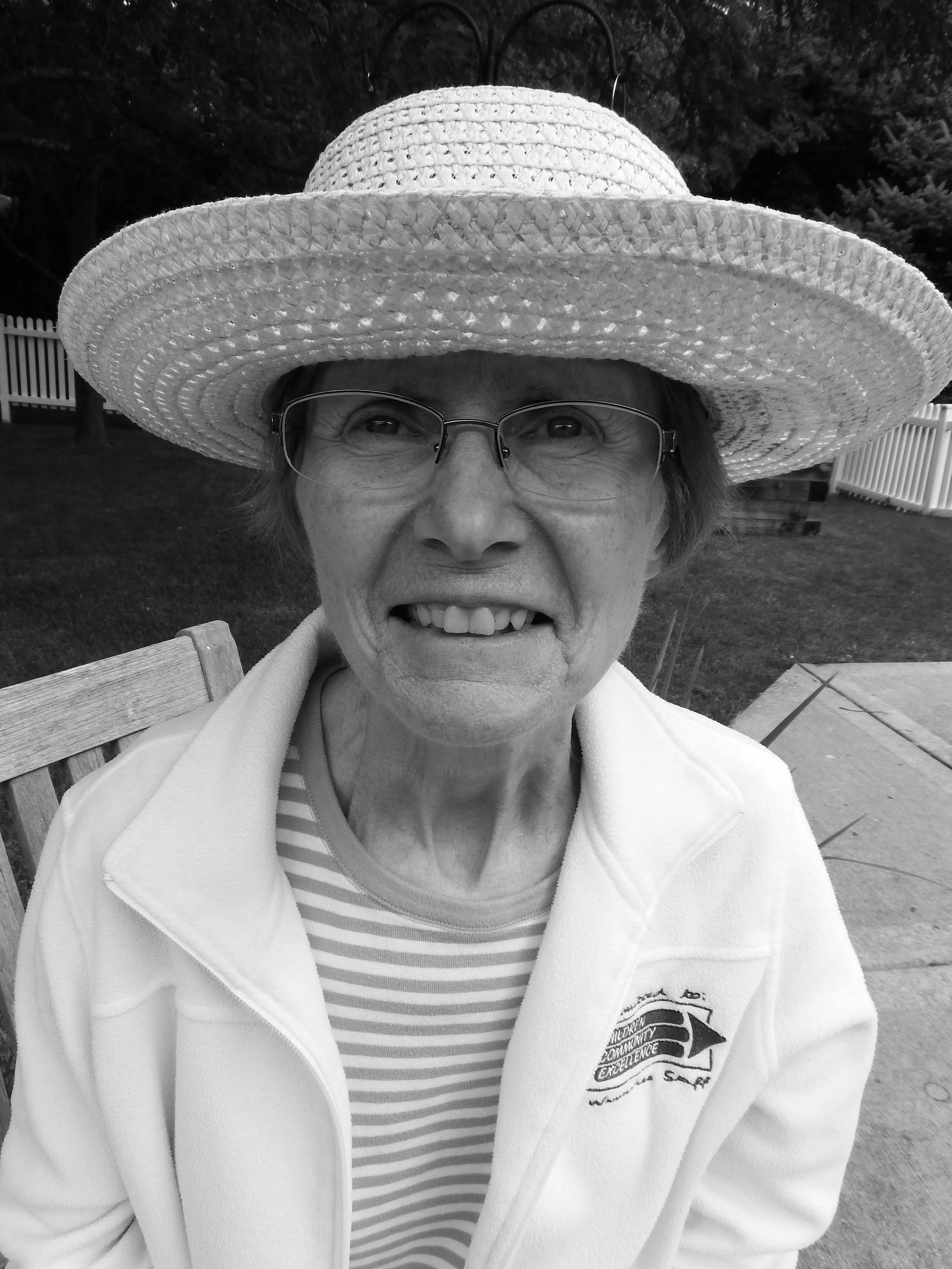 Resident smiling outdoors in sun hat